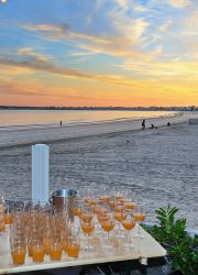 préparation avec table et cocktail pour un evenement pro au coucher de soleil sur la plage de la Baule