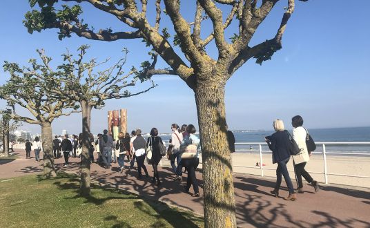 Groupe de personnes en balade sur la promenade qui longe la plage de La Baule, à proximité du Palais des congrès de la Baule Evénements