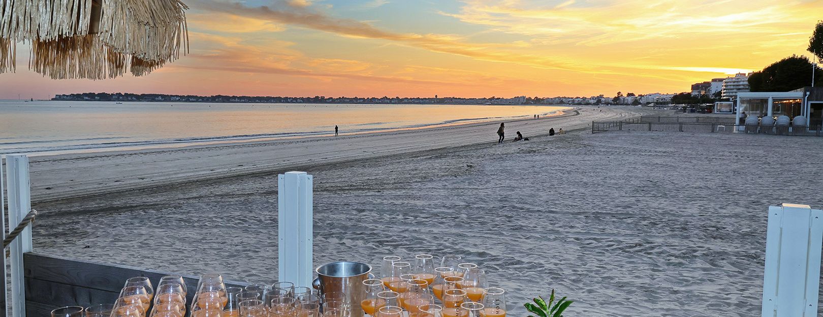 préparation avec table et cocktail pour un evenement pro au coucher de soleil sur la plage de la Baule