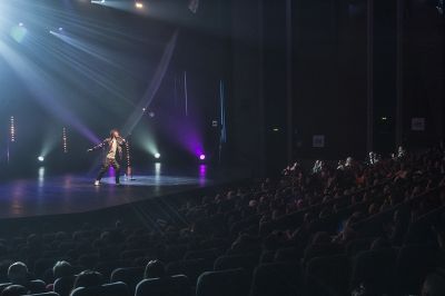 Vue sur un chanteur sur la scène de l'auditorium de la Baule avec une salle comble de spectateurs