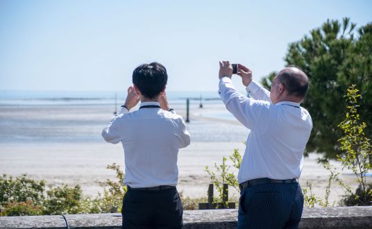 séminariste de dos en train de photographier la plage de la Baule