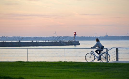 photo d'un cycliste en balade au couché du soleil sur le Front de mer de Saint Nazaire