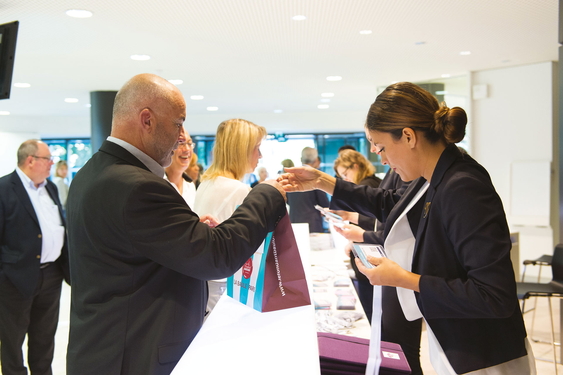 Borne d'accueil du palais des congrès La Baule avec du personnel accueillant les séminaristes