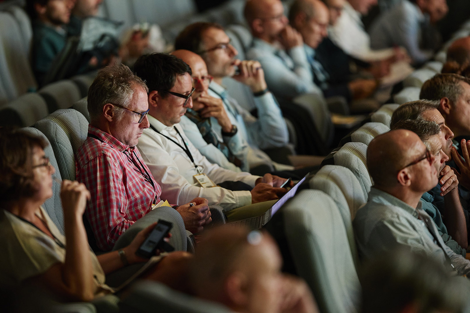 spectateurs avec teléphone en main sur siège de l'auditorium lors d'un evenement digital connecté organisé par la baule evenements